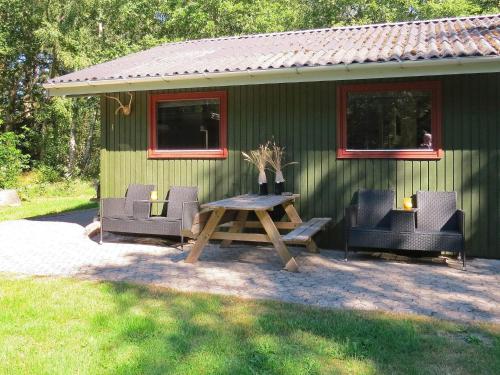 a picnic table and chairs in front of a cabin at 4 person holiday home in Hals in Hals