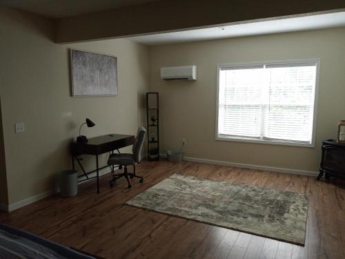 an empty living room with a desk and a window at Tranquil Creekside Mountain View Getaway in Clyde