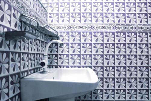 a white sink in a bathroom with blue and white tiles at Hotel Indropuri International in Dhaka