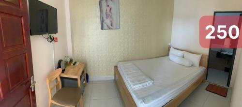 a small room with a small bed and a desk at Khách Sạn HOÀNG KIM in Bạc Liêu