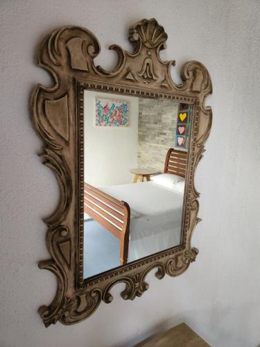 a mirror on a wall with a bed in it at Buddha Suítes in Pipa