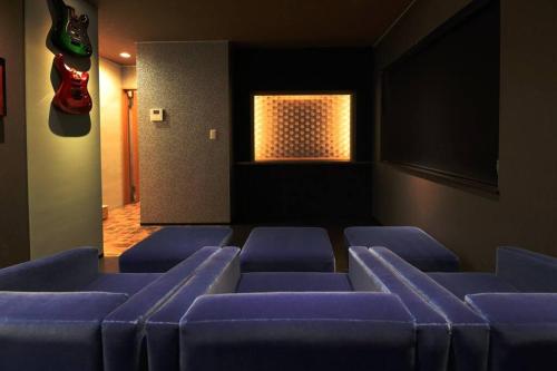 a waiting room with blue chairs and a window at The BEEHIVE OTARU in Otaru