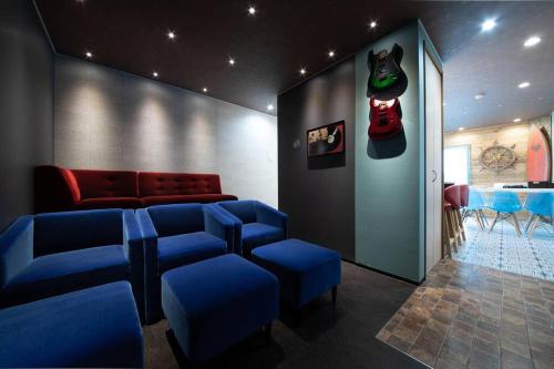 a waiting room with blue chairs and a red couch at The BEEHIVE OTARU in Otaru