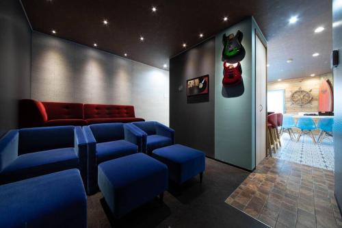 a waiting room with blue chairs and a red couch at The BEEHIVE OTARU in Otaru