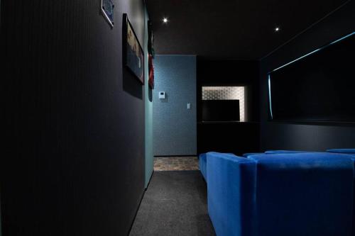 a dark room with blue chairs and a window at The BEEHIVE OTARU in Otaru