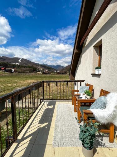a balcony with benches and a view of a field at Dovolenková chata Valča in Valča