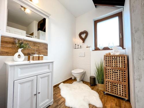 a bathroom with a white toilet and a window at Dovolenková chata Valča in Valča