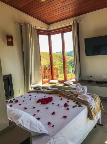a bedroom with a bed with red roses on it at Cabana Sol - Estalagem Meraki, Cunha SP in Cunha