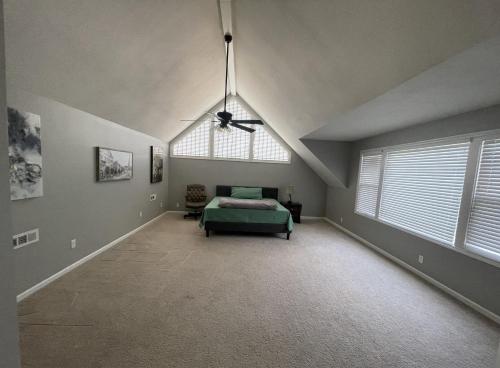 um quarto com uma cama e uma ventoinha de tecto em Beautiful Private West Knoxville Home 2700sf, 4 Beds, 2 & half Baths em Knoxville