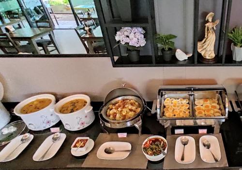 a table topped with bowls and plates of food at J.P.GRAND HOTEL in Trat