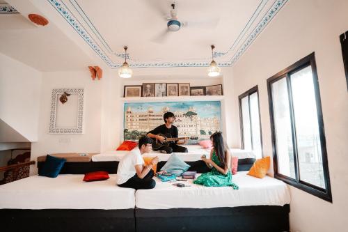 a group of people sitting on beds in a room at Citylights By MUSAFIR in Udaipur