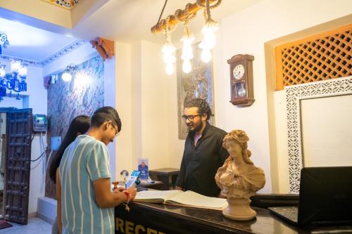 a man and a woman standing at a counter in a shop at Citylights By MUSAFIR in Udaipur