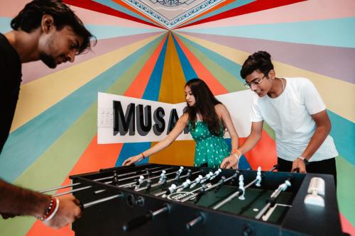 a group of three people standing around a chessboard at Citylights By MUSAFIR in Udaipur