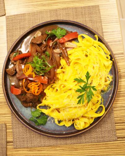 a plate of food with noodles and meat and vegetables at Hotel Gran Palma Huancayo in Huancayo