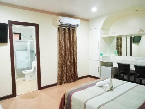 um quarto de hotel com uma cama e uma casa de banho em Villa Marinelli Bed and Breakfast em Tagaytay