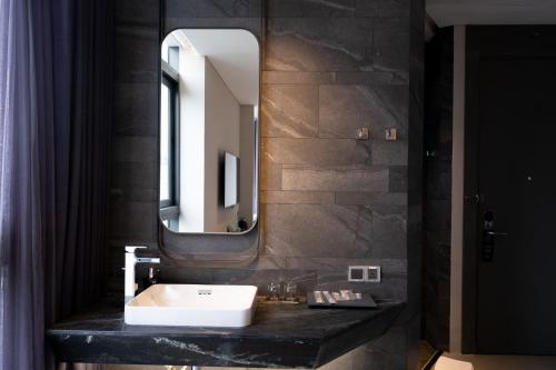 a bathroom with a sink and a mirror at M Hotel Saigon in Ho Chi Minh City