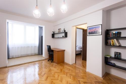 a living room with a desk and a bedroom at Central Apartment Targu Mures in Târgu-Mureş