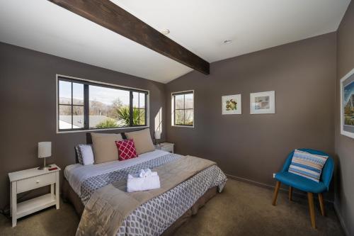 1 dormitorio con 1 cama y 1 silla azul en Criffel Peak View Bed and Breakfast en Wanaka