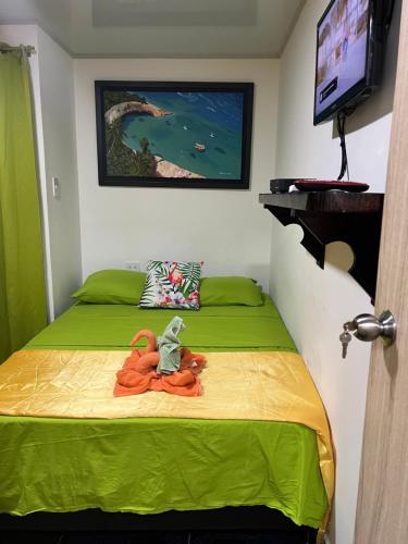 a bedroom with a green bed with a toy on it at Posada Ashanty in Providencia