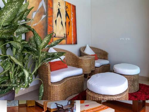 a room with three wicker chairs and a painting at Raya Beachloft in Rawai Beach