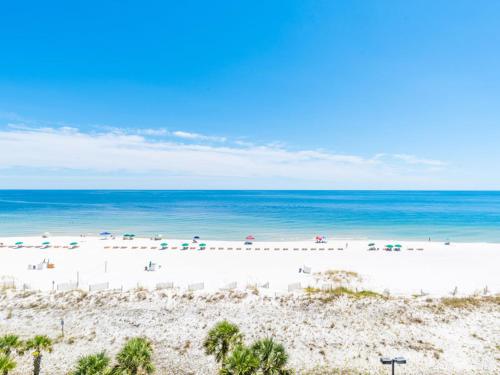 une plage avec des chaises et des parasols et l'océan dans l'établissement Regency Isle #512, à Orange Beach