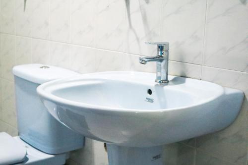 a bathroom with a white sink and a toilet at Sitha's Heaven in Ella