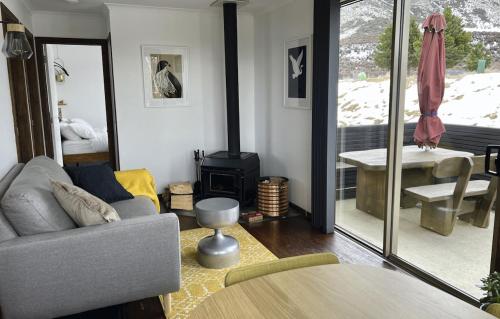 uma sala de estar com um sofá e uma mesa em Te Manahuna Retreat em Twizel