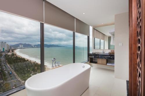 a bathroom with a tub and a view of the ocean at Asteria Comodo Nha Trang Hotel in Nha Trang