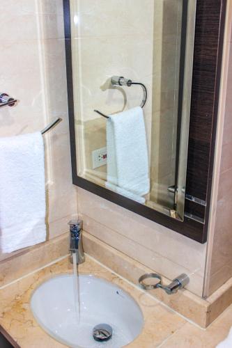 a bathroom with a sink and a mirror and towels at Holly Hotel in Duitama