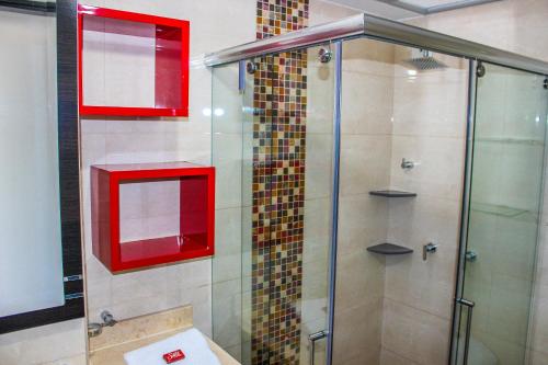a glass shower with red windows in a bathroom at Holly Hotel in Duitama