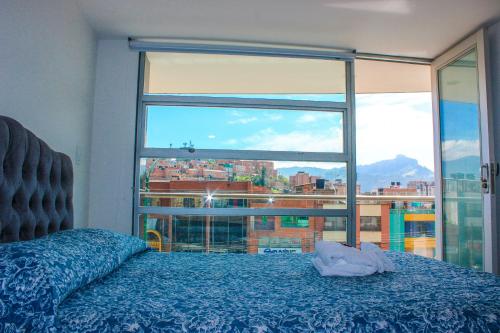 a bedroom with a bed and a large window at Holly Hotel in Duitama