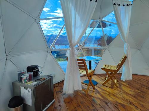 a room with a tent with a table and a chair at Glamping Amaru in Guatavita