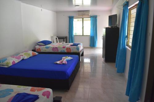 Tauramena的住宿－Finca Ecoturística Canaguaros，配有蓝色窗帘的客房内的两张床