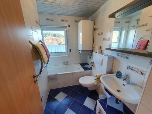 łazienka z umywalką, toaletą i wanną w obiekcie Ferienhaus Sonnengelb im Herzen des Schwarzwaldes w mieście Schönwald