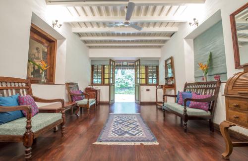 a living room with chairs and a rug at Pepper Trail in Sultan Bathery