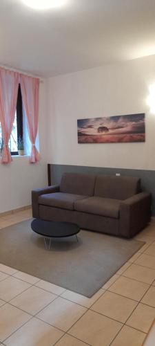 a living room with a brown couch and a table at Anna's Home in Campione dʼItalia