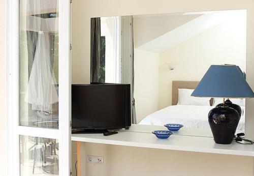 un televisor sentado en un estante en un dormitorio en Swiss Residence Montenegro, en Herceg-Novi