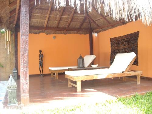 a room with two beds and a person standing in the background at Mandinka Lodge in Kololi