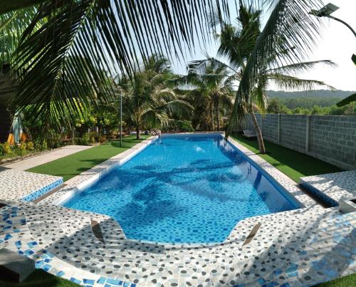 - une piscine avec 2 chaises longues et un complexe dans l'établissement Phu Nam House - Resort, à Duong Dong