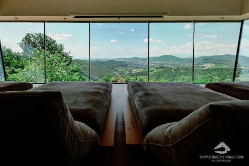 a living room with couches in front of a large window at Schmolti's Chalet in Graz