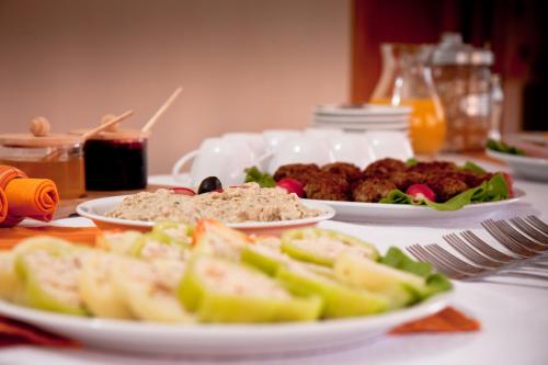 a table with plates of food on a table at Pension Panorama in Odorheiu Secuiesc