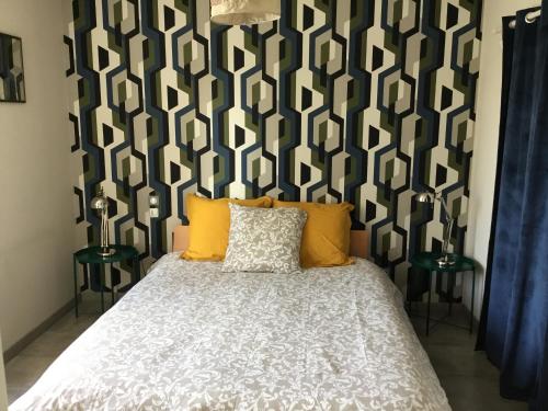 1 dormitorio con 1 cama con pared estampada en blanco y negro en Au bord de l'eau, en Charentenay