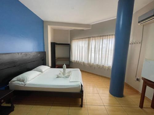 a bedroom with a bed and a blue wall at Alojamiento Tahuari - Iquitos- Perú in Iquitos