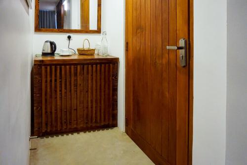 a room with a wooden door and a kitchen with a counter at Birds Park Polgahawela in Egalla
