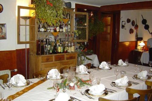 Hotel & Restaurant Raisch في Steinwenden: غرفة طعام مع طاولة مع مفارش المائدة البيضاء والأكواب