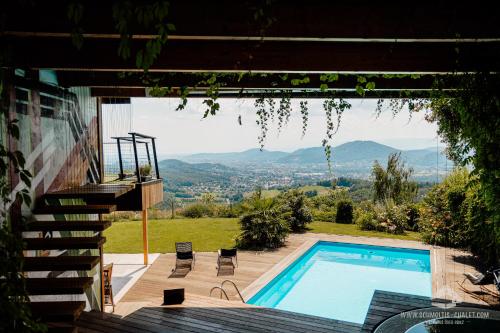 a house with a swimming pool and mountains in the background at Schmolti's Chalet in Graz