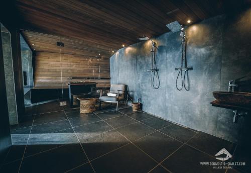 a bathroom with a sink and a chair in a room at Schmolti's Chalet - Wellness über Graz in Zösenberg