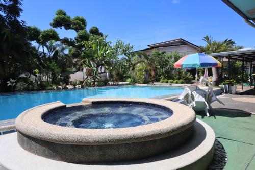 a swimming pool with a hot tub next to a swimming pool at Ice Bear Bar & Tourist Inn in Dauis