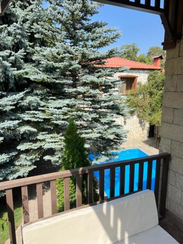 un banco blanco en un balcón con un pino en Kirovi Tun en Dilijan