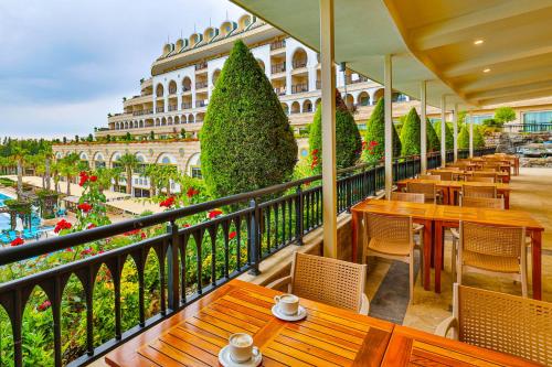 uma varanda com mesas e cadeiras e um edifício em Crystal Sunset Luxury Resort & Spa - Ultimate All Inclusive em Side